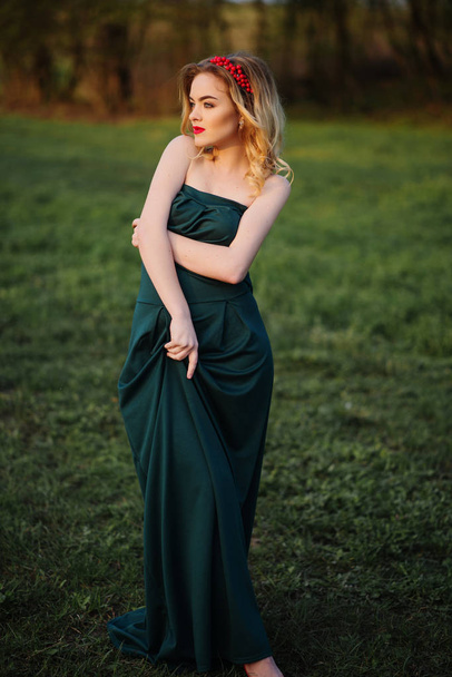 Yong elegance blonde girl at green dress on the garden in spring - Fotoğraf, Görsel