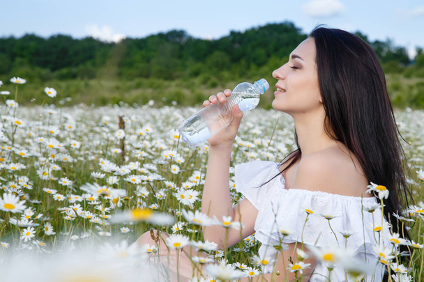 Beautiful woman on a flower granden enjoying her time outdoors - Foto, Imagen