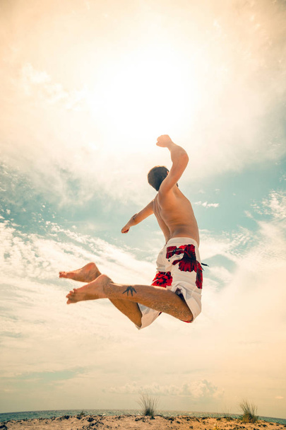 mężczyzna plaża siatkarka gry skakać na gorącym piasku - Zdjęcie, obraz