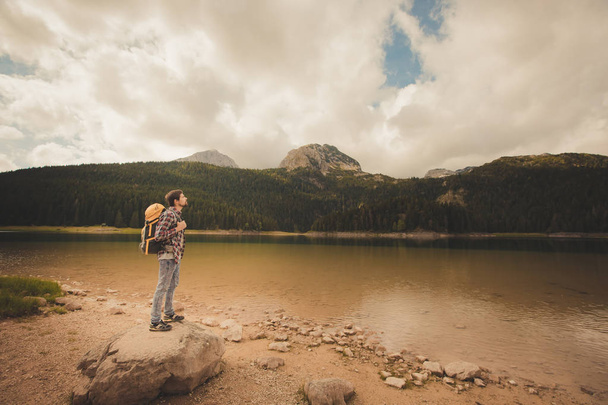 Młody człowiek patrzący na Black Lake, Durmitor National Park, Zabljak, Czarnogóra - Zdjęcie, obraz