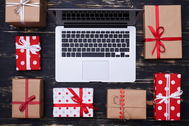 Boxes wrapped with colorful paper with a laptop in the center - Foto, Imagem
