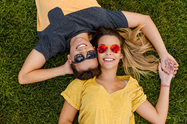 beautiful couple lying on grass - Zdjęcie, obraz