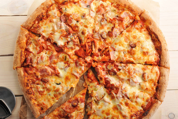 Pizza se sýrem a pikantní klobásy nakrájíme na plátky - Fotografie, Obrázek
