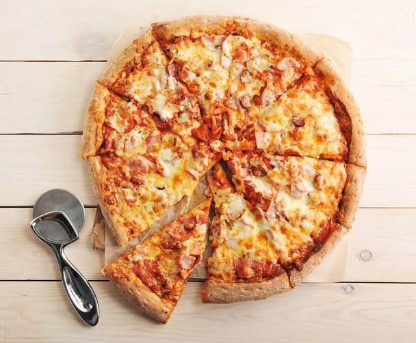 Pizza se sýrem a pikantní klobásy nakrájíme na plátky - Fotografie, Obrázek