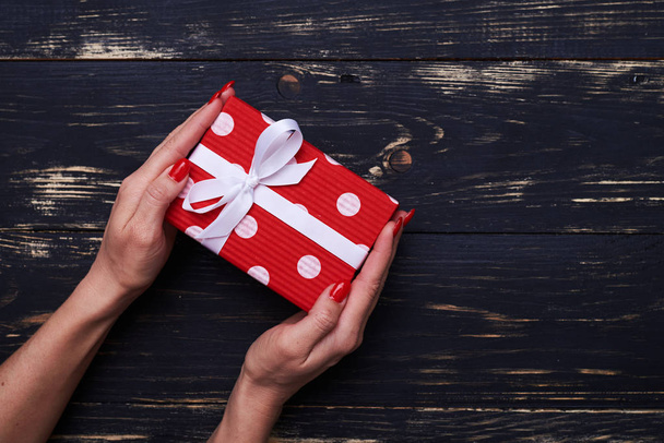 Caja de regalo roja y blanca con cinta blanca sobre diseño plano
  - Foto, imagen