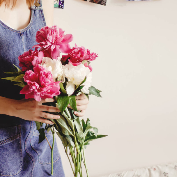 hipster in denim dress holding peony bouquet  - Photo, Image