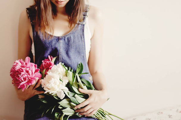hipster in denim dress holding peony bouquet  - Photo, Image