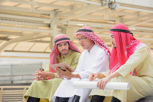Arabe gens d'affaires assis et consultant en utilisant la tablette
. - Photo, image