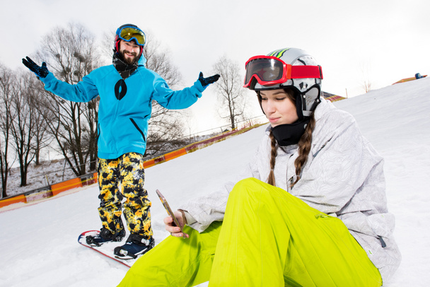 Vrouwelijke snowboarder met smartphone - Foto, afbeelding
