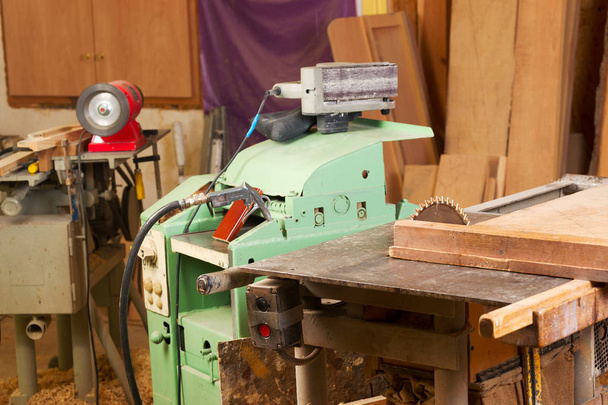 ほこりを持つ木製のテーブルの上の大工道具。サーキュラー・ソー。大工の職場のトップビュー - 写真・画像