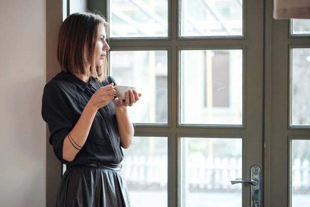 Pretty woman holding coffee. - Foto, Bild