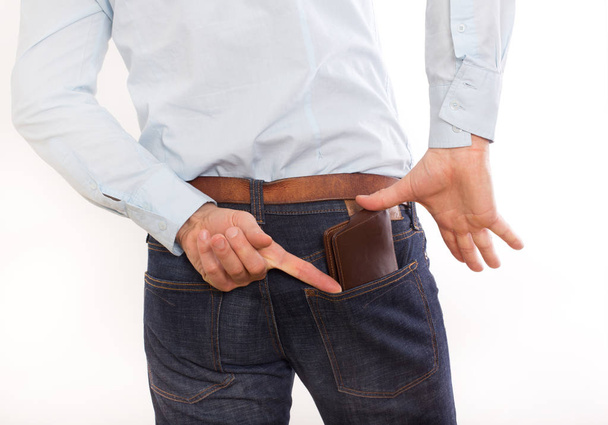 чоловік кладе гаманець у задню кишеню
 - Фото, зображення