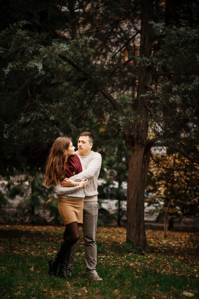 Young couple wearing on tied warm sweaters hugging in love at ci - Fotoğraf, Görsel