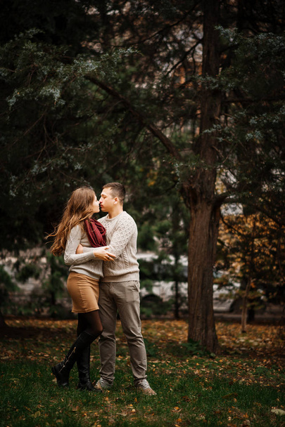 jovem casal vestindo no amarrado quente suéteres abraçando no amor no ci
 - Foto, Imagem