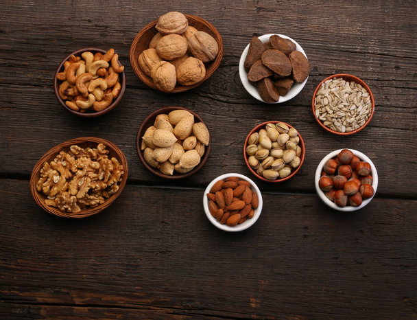 Gruppe köstlicher Trockenfrüchte vor einem hölzernen Hintergrund. Nüsse, Mandeln, Pistazien - Foto, Bild