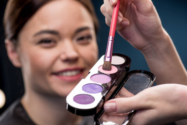 Woman picking up color of eyeshadows - Photo, Image