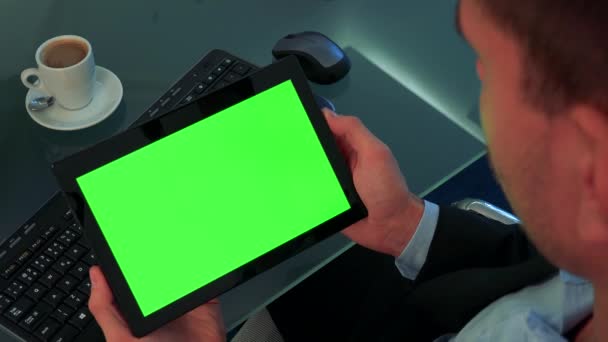 A man looks at a tablet with a green screen - Footage, Video