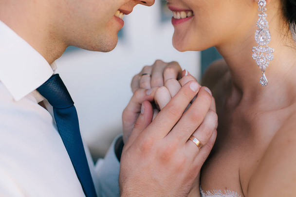 Pareja de amantes sonriendo y tomados de la mano con anillos, la novia y el novio
 - Foto, Imagen