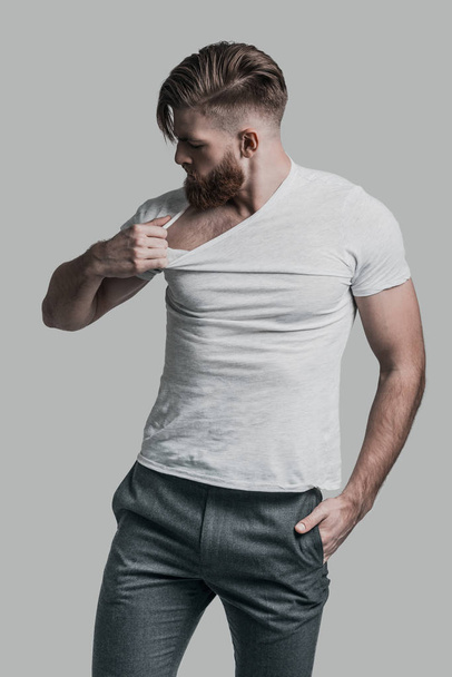 man with beard pulling his T-shirt - Foto, afbeelding