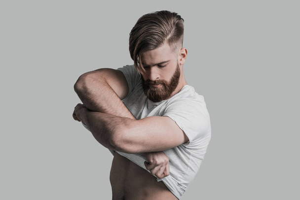 man with beard taking off his T-shirt - Fotoğraf, Görsel