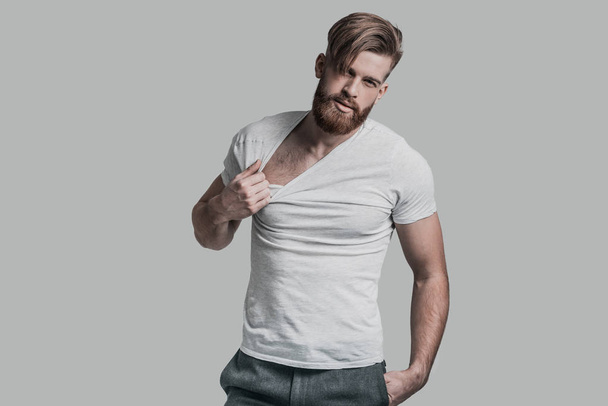 man with beard pulling his T-shirt - Fotografie, Obrázek