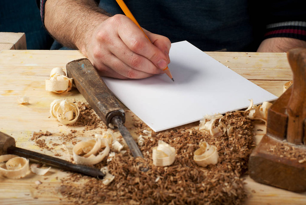 Sábana blanca sobre mesa de madera para herramientas de carpintería con serrín
. - Foto, imagen