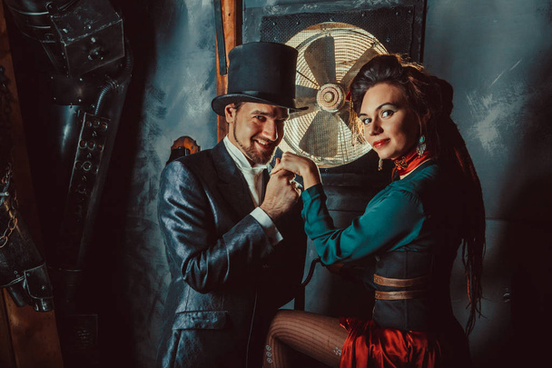 Joli couple flirtant vêtu de costumes vintage sur le fond de la pièce sombre
. - Photo, image