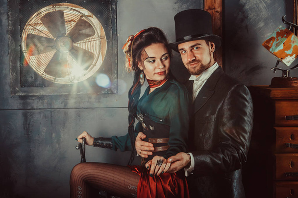 Pretty flirting couple dressed in vintage costumes on the dark room background. - Photo, Image