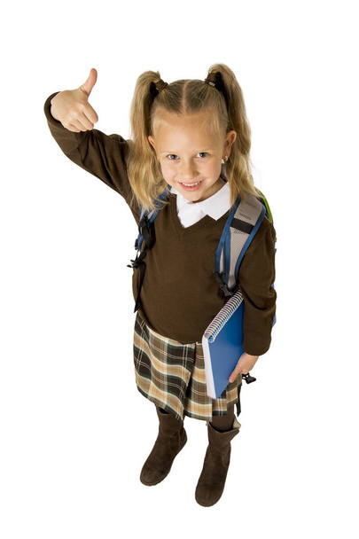 happy young beautiful blond schoolgirl with pigtails and school uniform carrying backpack  - Photo, Image