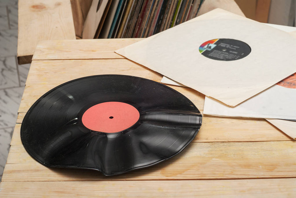 Image de style rétro d'une collection de vieux disques vinyle lp avec des manches sur un fond en bois. Parcourir la collection de disques vinyle. Musique de fond. Espace de copie
 - Photo, image