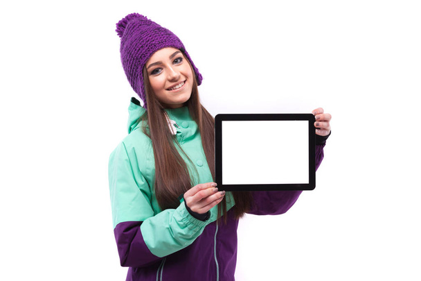 mooie meisje in ski pak met lege tablet - Foto, afbeelding
