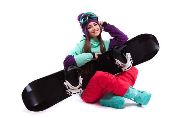 piękna dziewczyna siedzieć na skrzyżowane nogi z snowboard na kolana - Zdjęcie, obraz