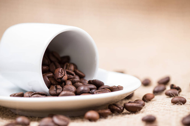 Bílé coffeecup s coffeebeans na pozadí gunny - Fotografie, Obrázek