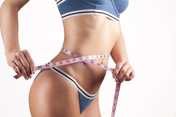 Woman measuring waistline, fitness and diet concept - Фото, изображение