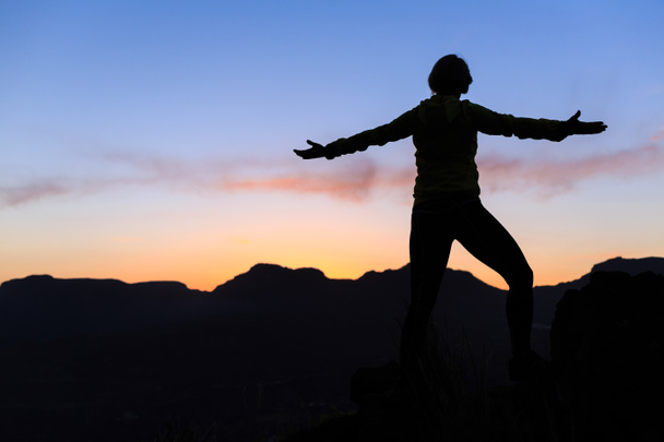 Силуэт успеха женщины в горах на закате
 - Фото, изображение