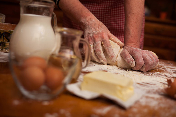 Senior woman hands knead dough on table in home kitchen - Foto, Imagem