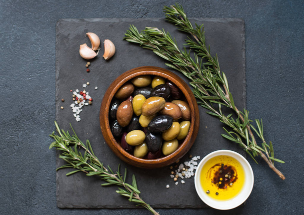 Olives and olive oil on dark stone - Fotografie, Obrázek