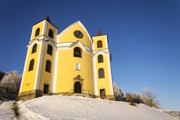 Kerk van veronderstelling in de besneeuwde bergen, Neratov, Tsjechië - Foto, afbeelding