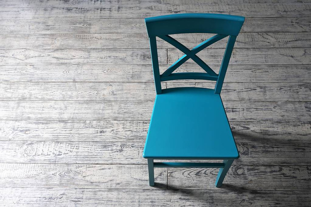 Σύγχρονο μπλε καρέκλα στέκεται στο ξύλινο παρκέ πάτωμα.  - Φωτογραφία, εικόνα