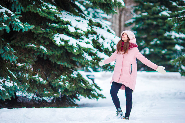 Счастливая девочка наслаждается зимней и снежной погодой на улице в прекрасный холодный день
 - Фото, изображение