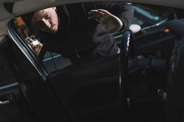 Auto κλέφτης που ψάχνει για εσωτερικό αυτοκινήτου - Φωτογραφία, εικόνα