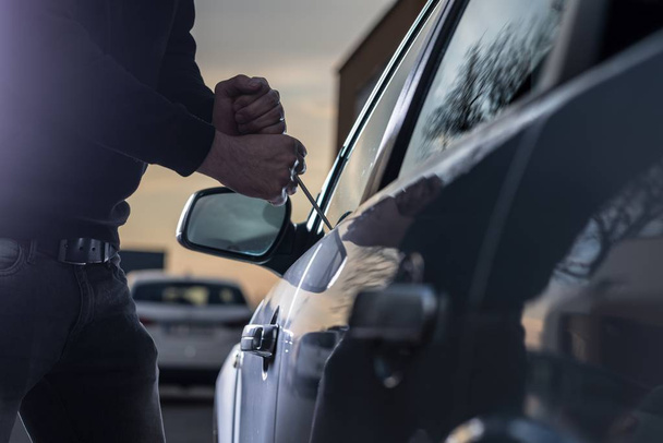 Siyah yün arabaya girmeye çalışan Oto hırsızı - Fotoğraf, Görsel
