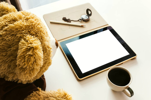 Cute bear doll watching taplet on table - Foto, Imagem