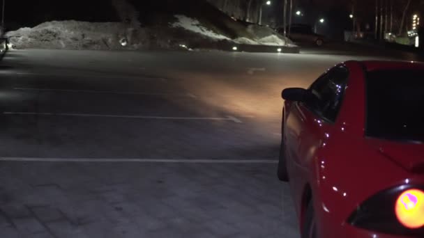 Red automobile rides backward at the parking. - Footage, Video