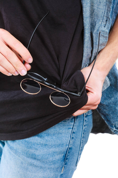 Man cleaning glasses on black t shirt - Photo, image