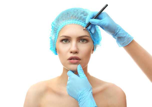 Plastic surgeon drawing line on face  - Foto, imagen