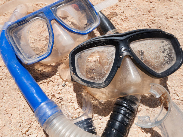A pair of mask and snorkels on a golden sandy beach, with a beautiful shallow depth of field. - Фото, зображення