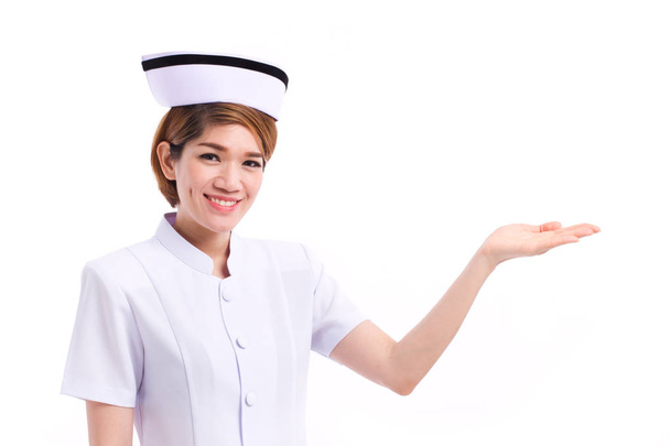 Lachende vrouw verpleegkundige presenteren, waaruit haar hand naar lege ruimte - Foto, afbeelding