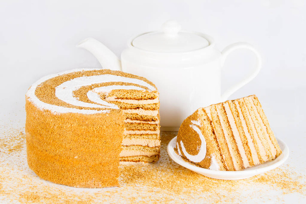 Honey cake and teapot on a golden tray - Photo, Image