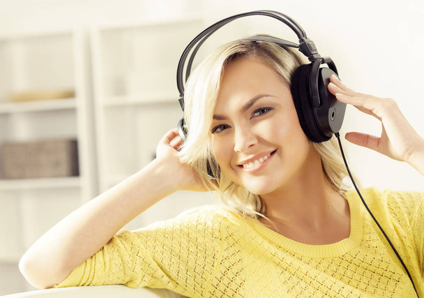 young woman listening music at home - Fotó, kép